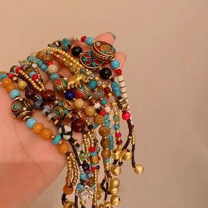 Gros plan de bracelets ethniques en perles colorées avec breloques en métal et clochettes