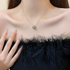 Close-up of triple-ring pendant necklace with crystals and engraving on a female model