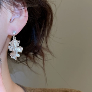 Macro view of ginkgo leaf dangle earring with sparkling rhinestone on silver metal