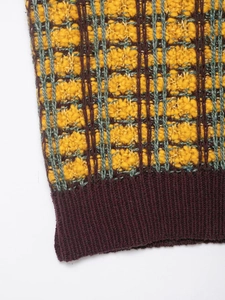 Detail shot of the textured knit vest showing yellow and purple plaid pattern weaving