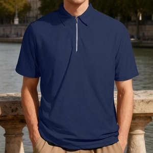 Men's navy blue polo shirt with jacquard texture and quarter-zip detail on outdoor model