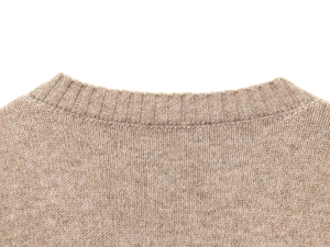 Gros plan sur la maille fine et l'encolure du pull en tricot marron doux pour femme