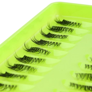 Close-up of 10 pairs natural thick half false eyelashes on neon green tray
