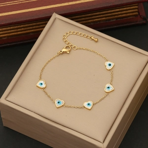 Detail of gold heart evil eye charms on a stainless steel chain with lobster clasp