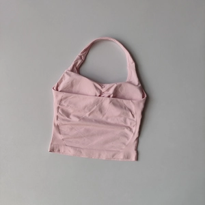 Close-up of pink halter yoga vest showing seamless ribbed texture and padded U-neck design
