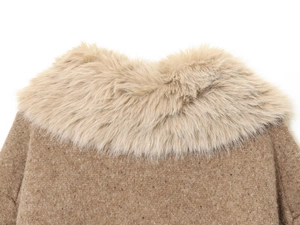 Macro view of the plush faux fur collar and textured wool blend knit fabric on a coat