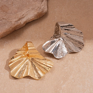 Exaggerated metal flower ring with hammered texture in gold and silver on sandstone