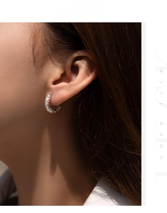 Macro shot of 925 silver moissanite hoop earrings worn by a model in warm light