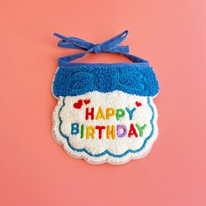 Close-up of blue knitted pet birthday bib with colorful Happy Birthday embroidery detail
