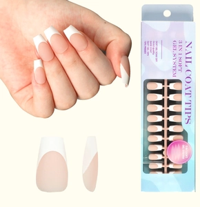 Detail of French tip press-on nails in matte pink and white with blue packaging box