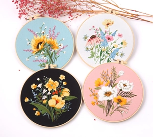 Close-up of four floral embroidery hoop kits with sunflower and daisy patterns