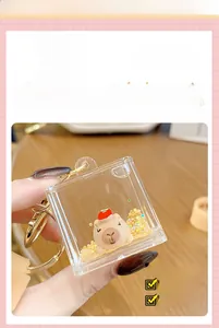 Macro detail of square acrylic capybara keychain with liquid quicksand and gold metal ring