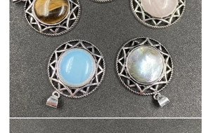Macro view of sunburst pendants featuring tiger eye, rose quartz, opal and abalone shell