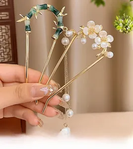 Détail d'épingles à cheveux en forme de U avec glands papillons et perles de style rétro