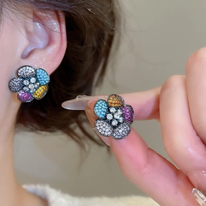 Macro detail of sparkling colorful zircon flower earring with refined gemstone settings