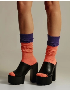 Detail of orange slouch socks with purple textured knit cuff and color-block design
