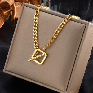 Elegant gold cuban link necklace with square toggle clasp on a beige jewelry box