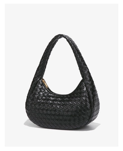 Detail shot of black woven leather texture and gold zipper on a chic hobo bag