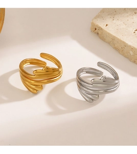 Detail of layered wavy rings in gold and silver finish with adjustable open design