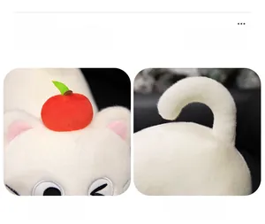 Detailed close-up of cute white cat plush toy with apple hat and embroidery details