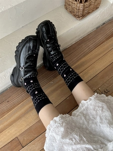 Détail de chaussettes à motif cœur rose avec chaussures Mary Jane noires et robe dentelle