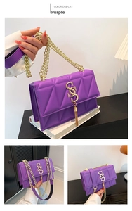 Detail view of purple quilted shoulder bag with golden S-buckle and tassel chain