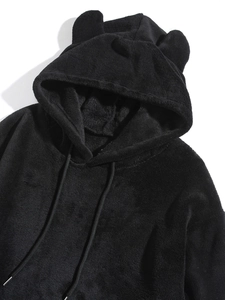 Close-up of black coral fleece hoodie featuring plush bear ears on the soft hood