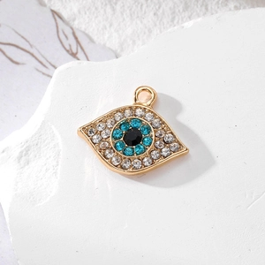 Macro view of gold devil eye pendant with blue and white crystals on stone base