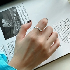 Detail of minimalist 925 sterling silver olive leaf ring worn on a finger