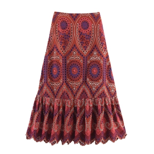 Dettaglio ravvicinato della gonna boho ruggine con ricami blu e finiture in pizzo traforato