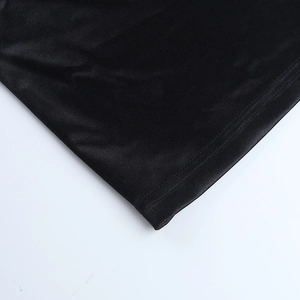 Gros plan détaillé de l'ourlet à double couture et du satin lisse sur la robe noire