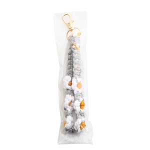 Detailed macro of handmade woven daisy flower strap with golden metal lobster clasp