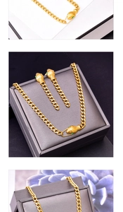 Close-up of golden snake head necklace and earrings set with green gemstone eyes