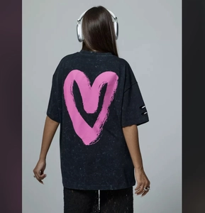 Detail of pink heart print and distressed acid wash texture on the back of a t-shirt