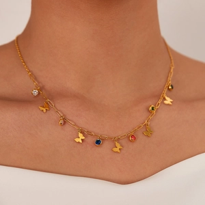 Detail of gold butterfly necklace with colorful zircon stones on female model's collarbone