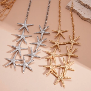 Gold and silver layered starfish necklaces with textured charms on a natural background