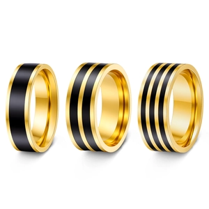 Detailed shot of three gold plated stainless steel rings with black stripe patterns