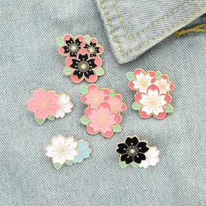 Detailansicht der Kirschblüten Emaille Anstecknadeln Set auf blauem Denim Hintergrund