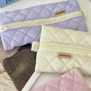Close-up of quilted macaron colored pencil cases with diamond texture and zipper