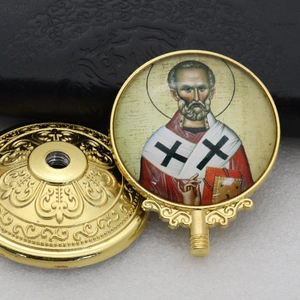 Detailed view of the gold-framed religious saint icon and decorative metallic base