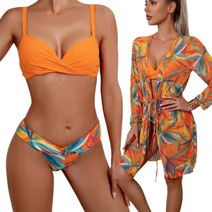 Three-piece orange bikini set with tropical leaf print swim shorts and long sleeve cover-up