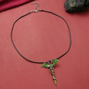 Vintage dragon pendant entwined on sword with black woven cord on red background