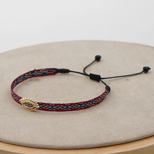 Detailed view of woven tribal bracelet with evil eye charm and adjustable cord