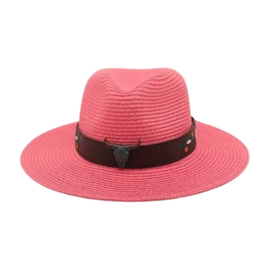 Détail d'un chapeau de paille rose avec emblème tête de taureau et broderie florale