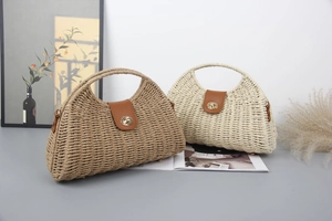 Detail of straw woven handbag featuring a leather flap and gold-tone metal twist lock