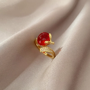 Macro view of gold-plated geometric ring with red stone and micro-pave zircons