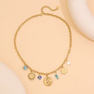 Détail du collier chaîne dorée avec breloques cœur bleu, ours, fleur et célestes