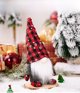 Detail of a Christmas gnome doll with red plaid hat in a festive snowy setting