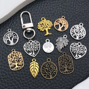 Tree of Life jewelry charms set in gold and silver finish on black background