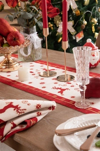 Detail of Christmas table runner featuring red reindeer jacquard and festive tassels